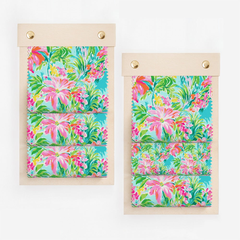 Fabric swatches with bright floral print on wooden clipboards.