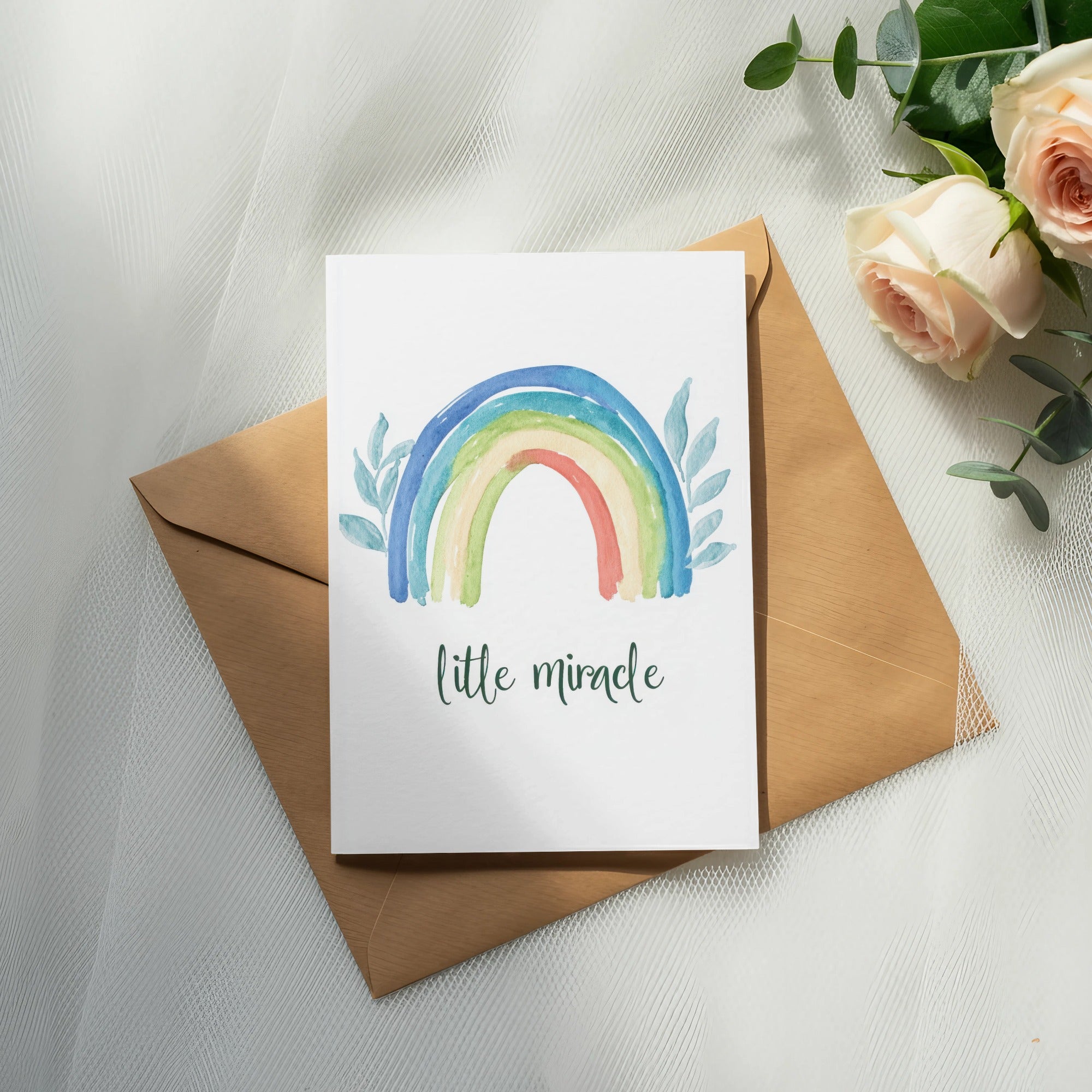 Watercolor rainbow card with "little miracle" text on a kraft envelope.