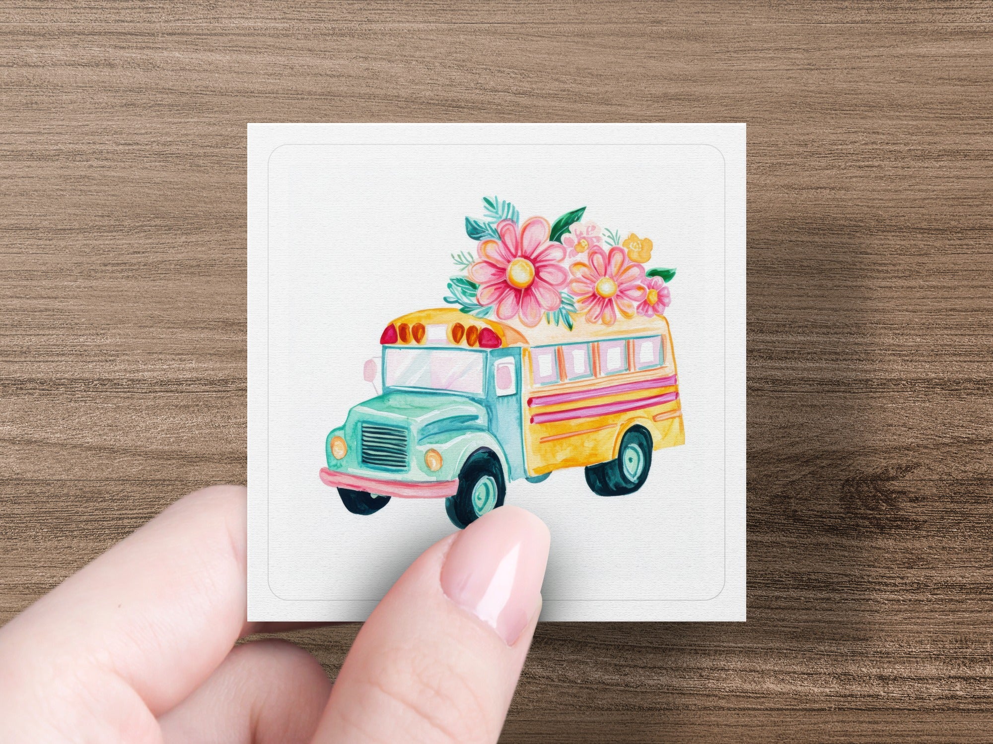 Watercolor illustration of a teal and yellow school bus adorned with colorful flowers.