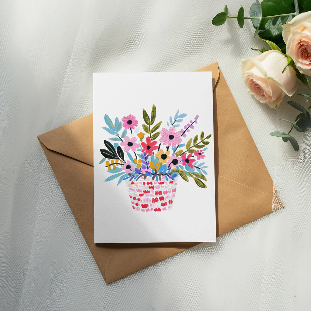 Watercolor illustration of a pink woven basket overflowing with colorful flowers.
