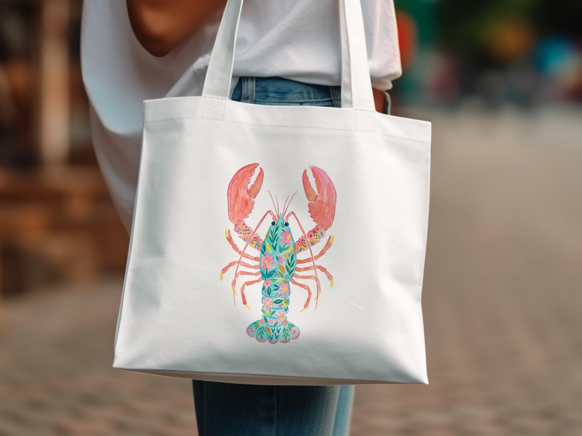 White tote bag with a colorful floral lobster illustration.