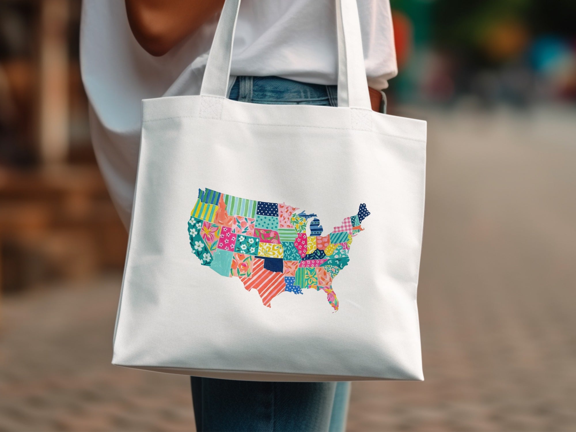 White tote bag with a colorful patchwork map of the United States.