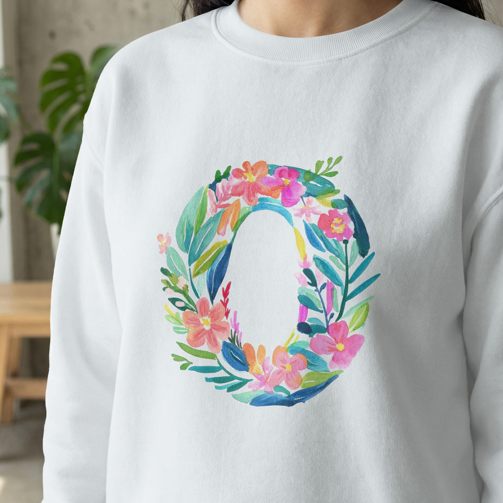 White sweatshirt with a floral letter O design in pink and green watercolor.