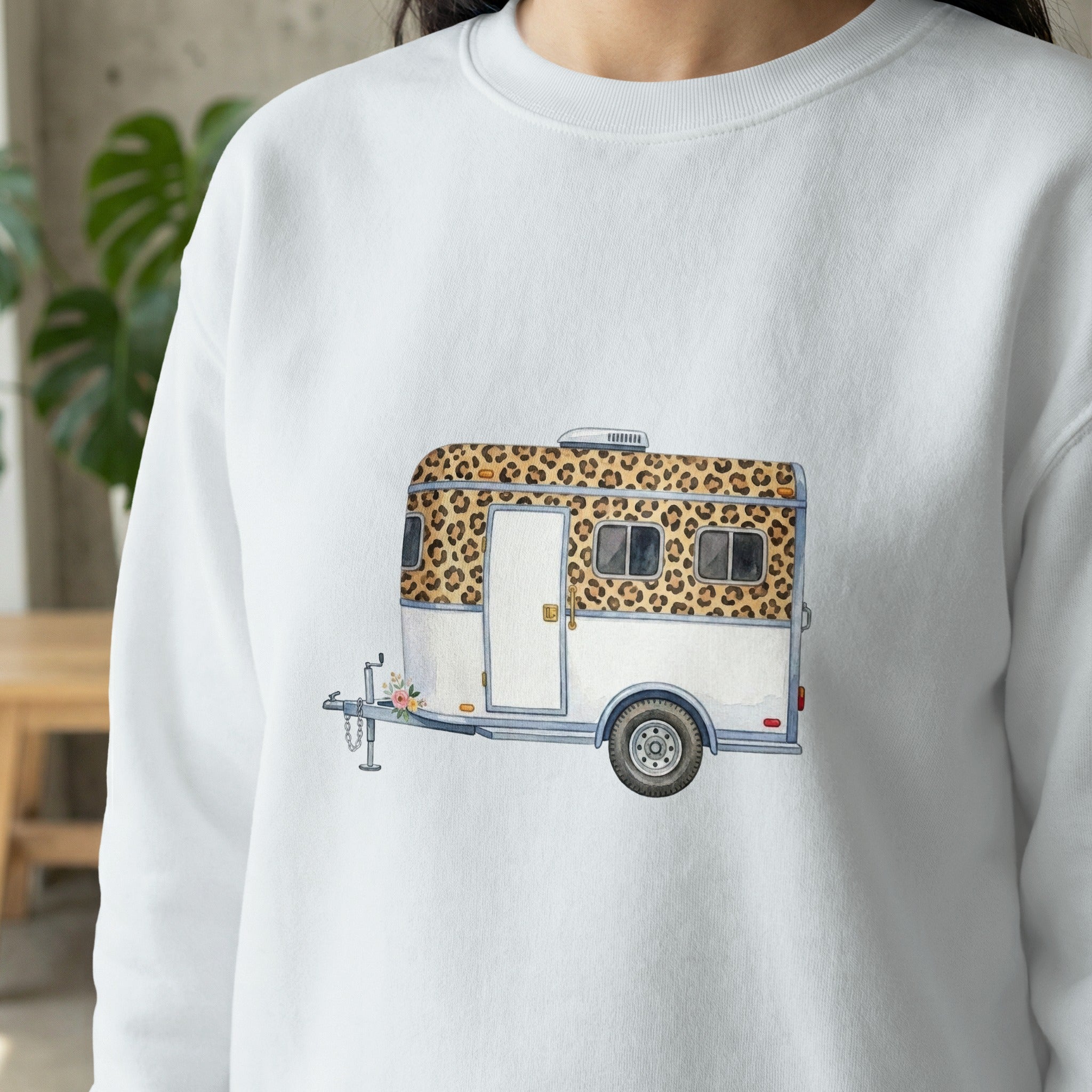 White sweatshirt with watercolor print of a leopard print and white travel trailer.