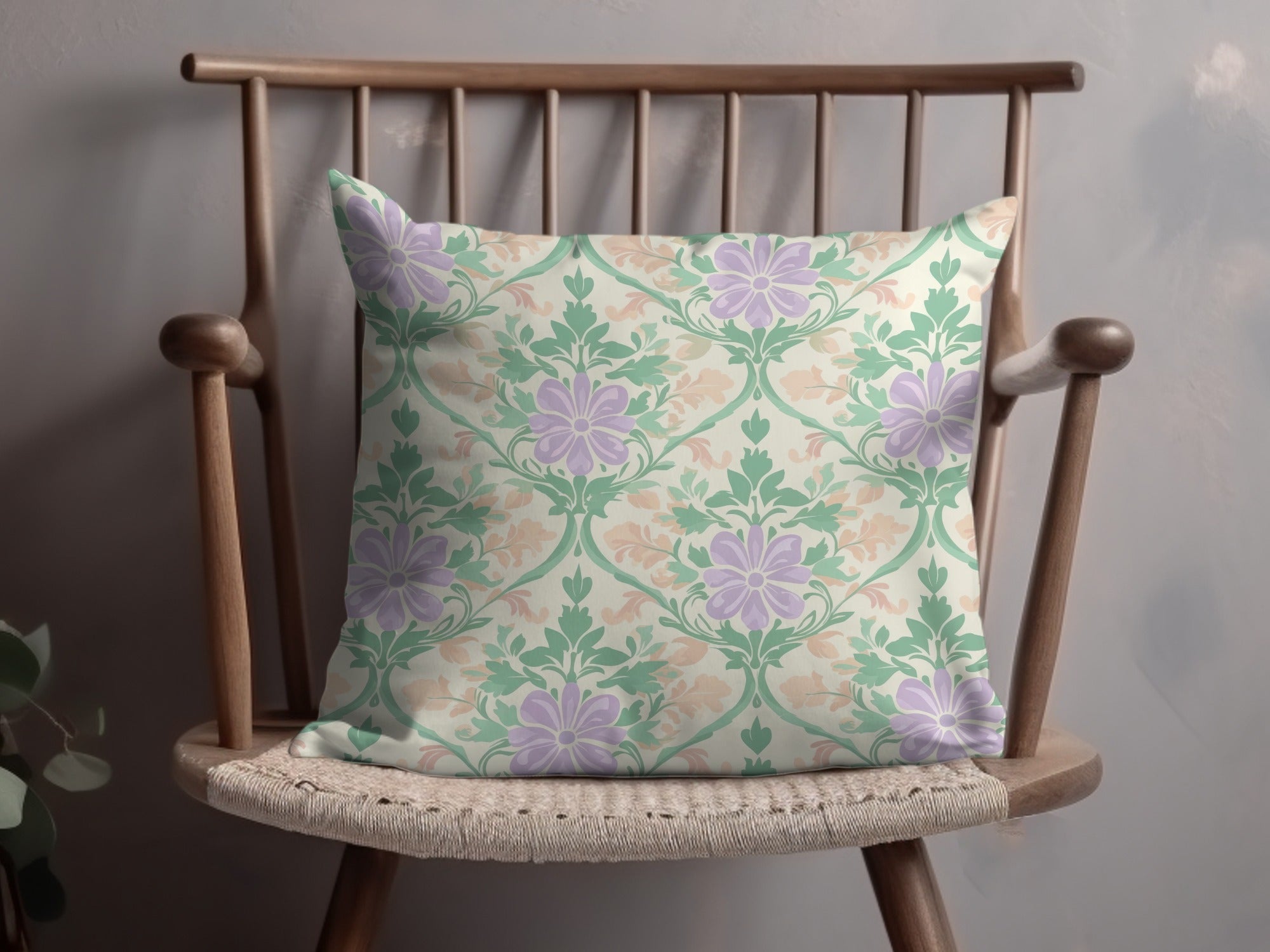 Pillow with floral pattern in green, purple, and peach on a wooden chair.