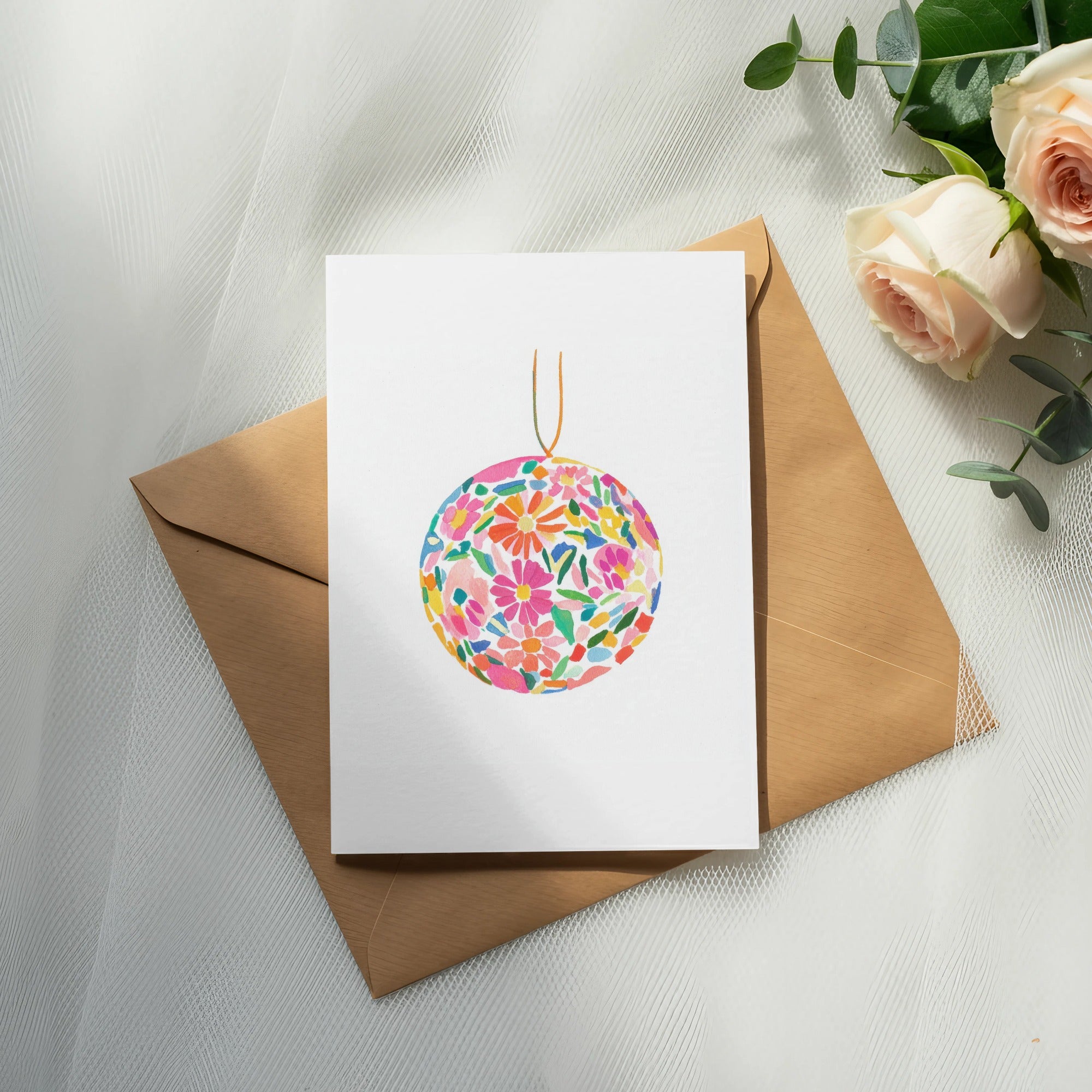 Blank card with colorful floral sphere illustration on brown envelope.