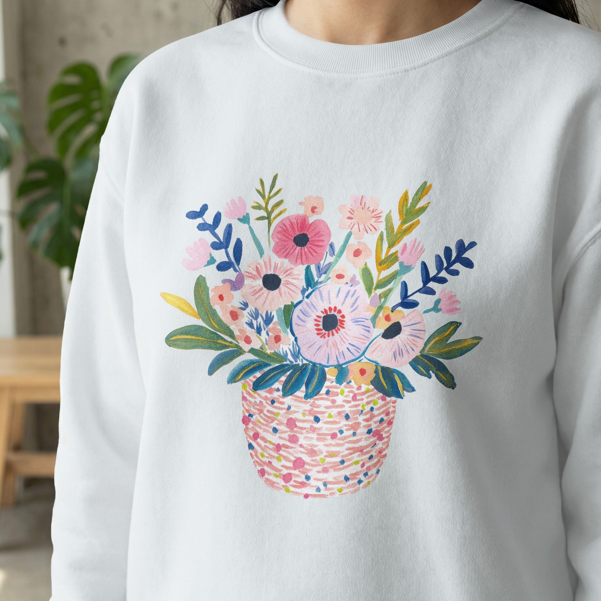 White sweatshirt with a colorful watercolor floral basket print.