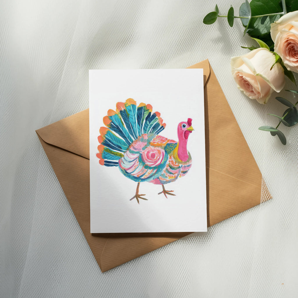 Colorful watercolor turkey on a card atop a brown envelope with roses.