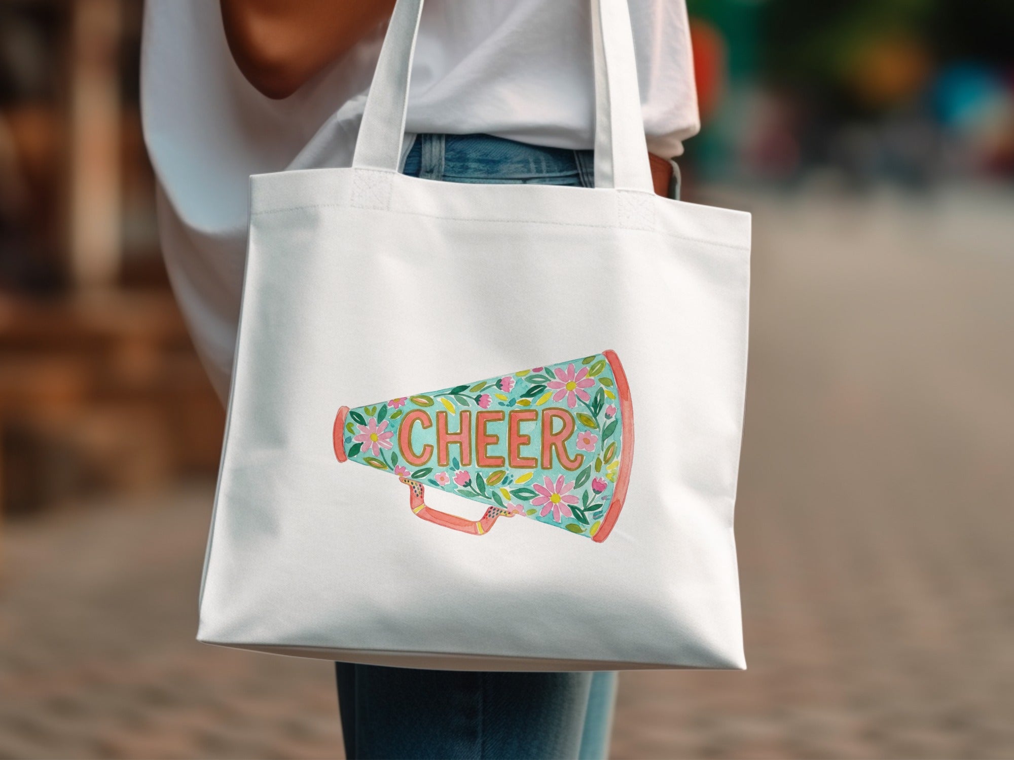 White tote bag with a colorful megaphone graphic that says "Cheer".