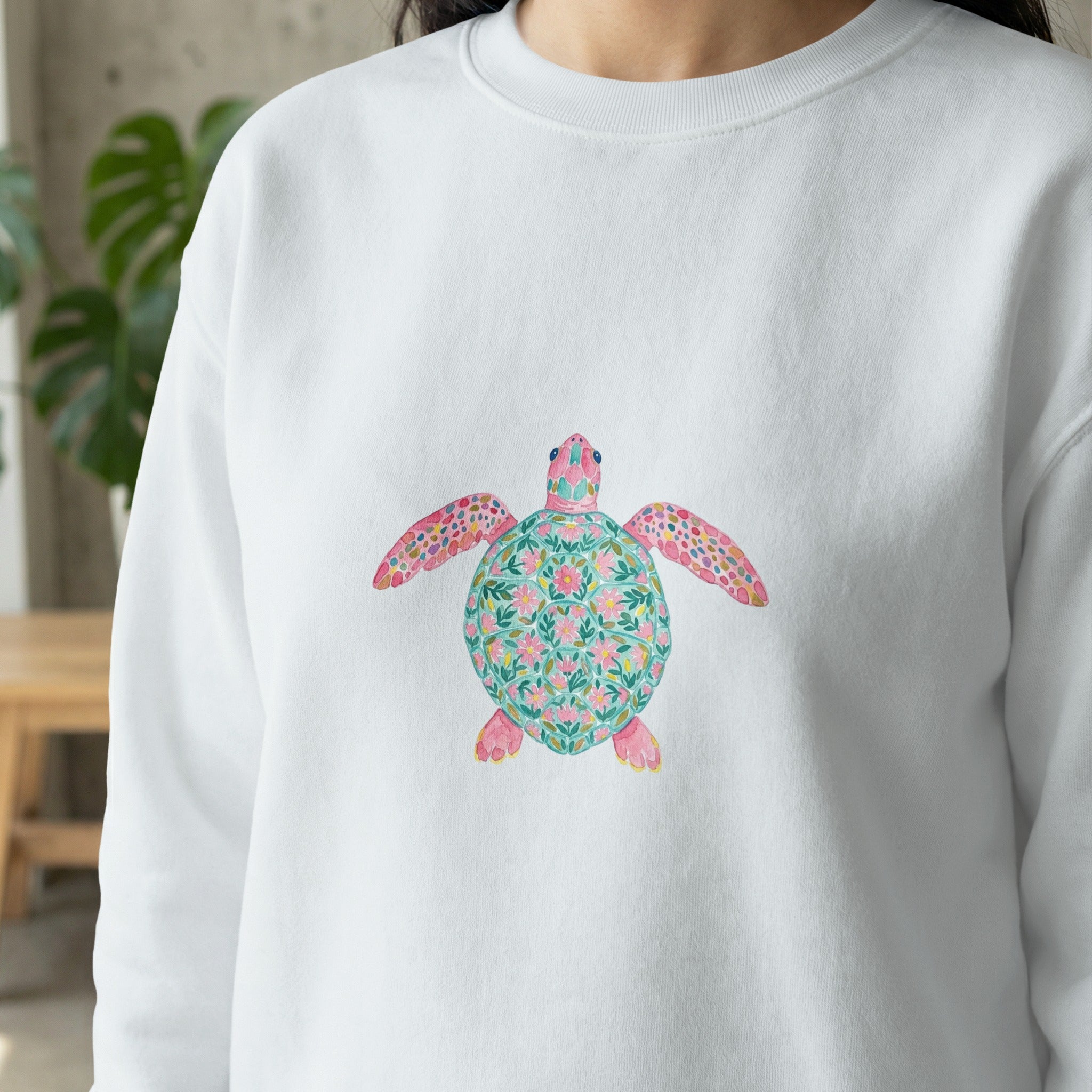 White sweatshirt featuring a colorful floral sea turtle graphic on the chest.