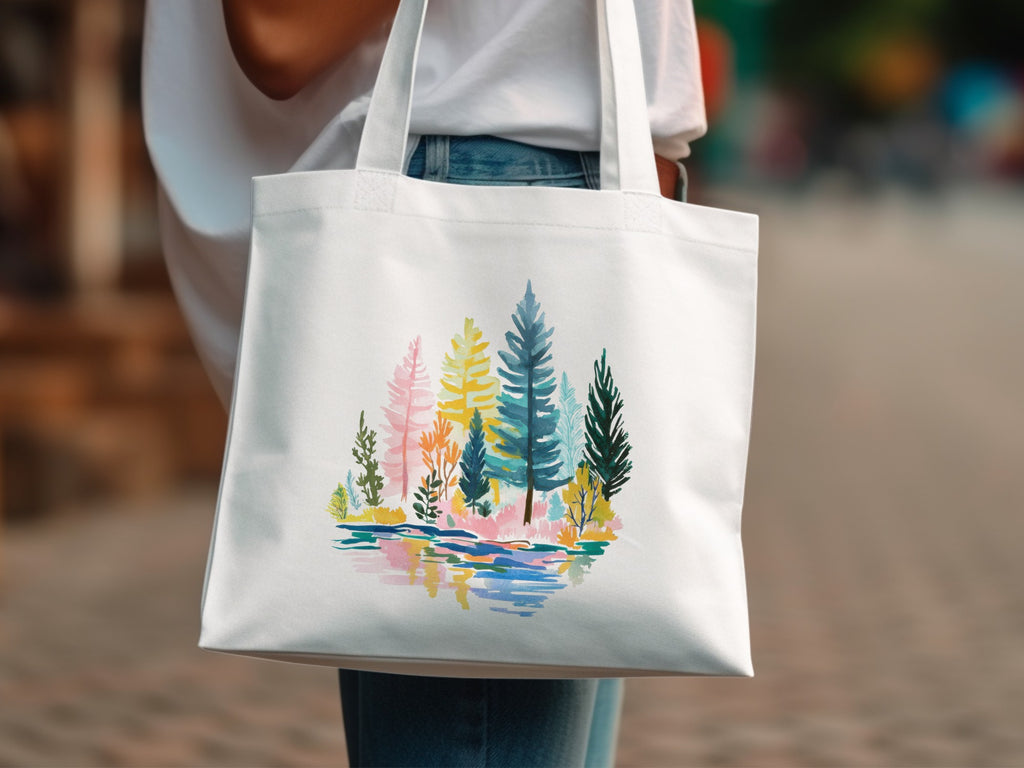 White tote bag with colorful forest and water illustration.