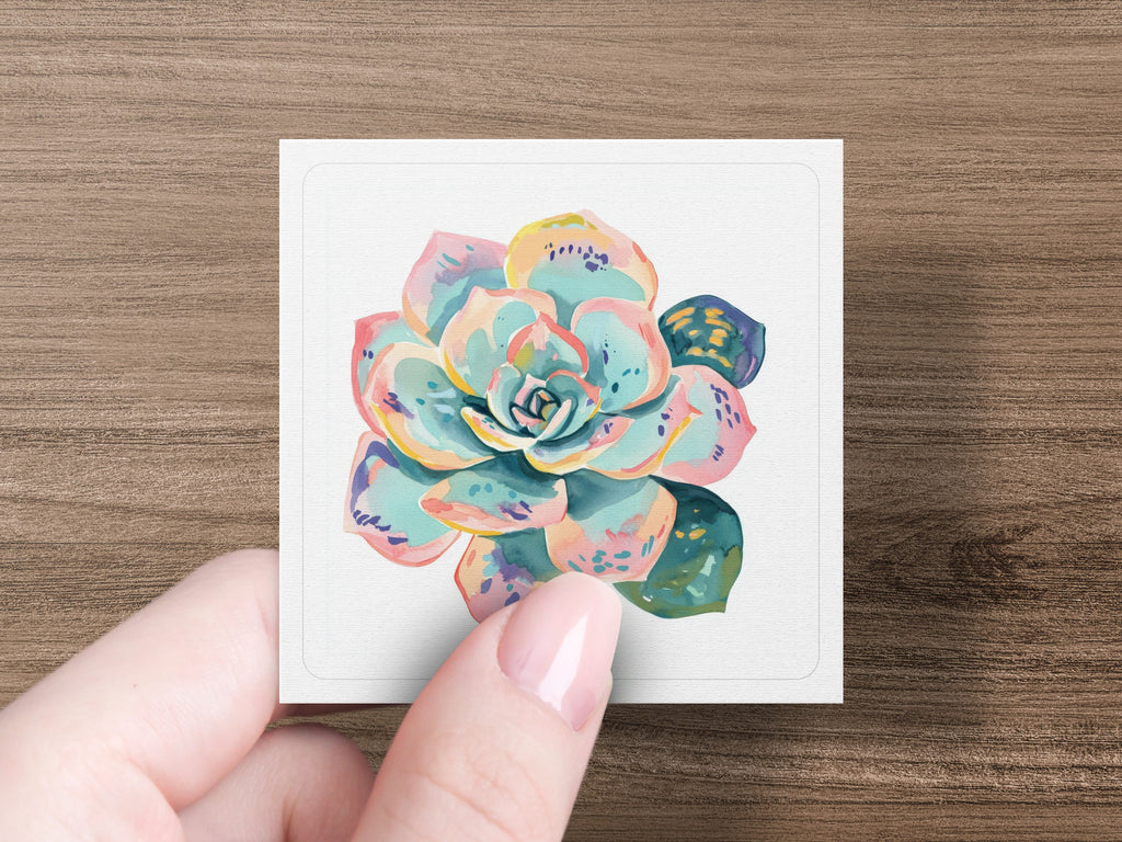 Watercolor succulent art on a card held by a person's fingers.