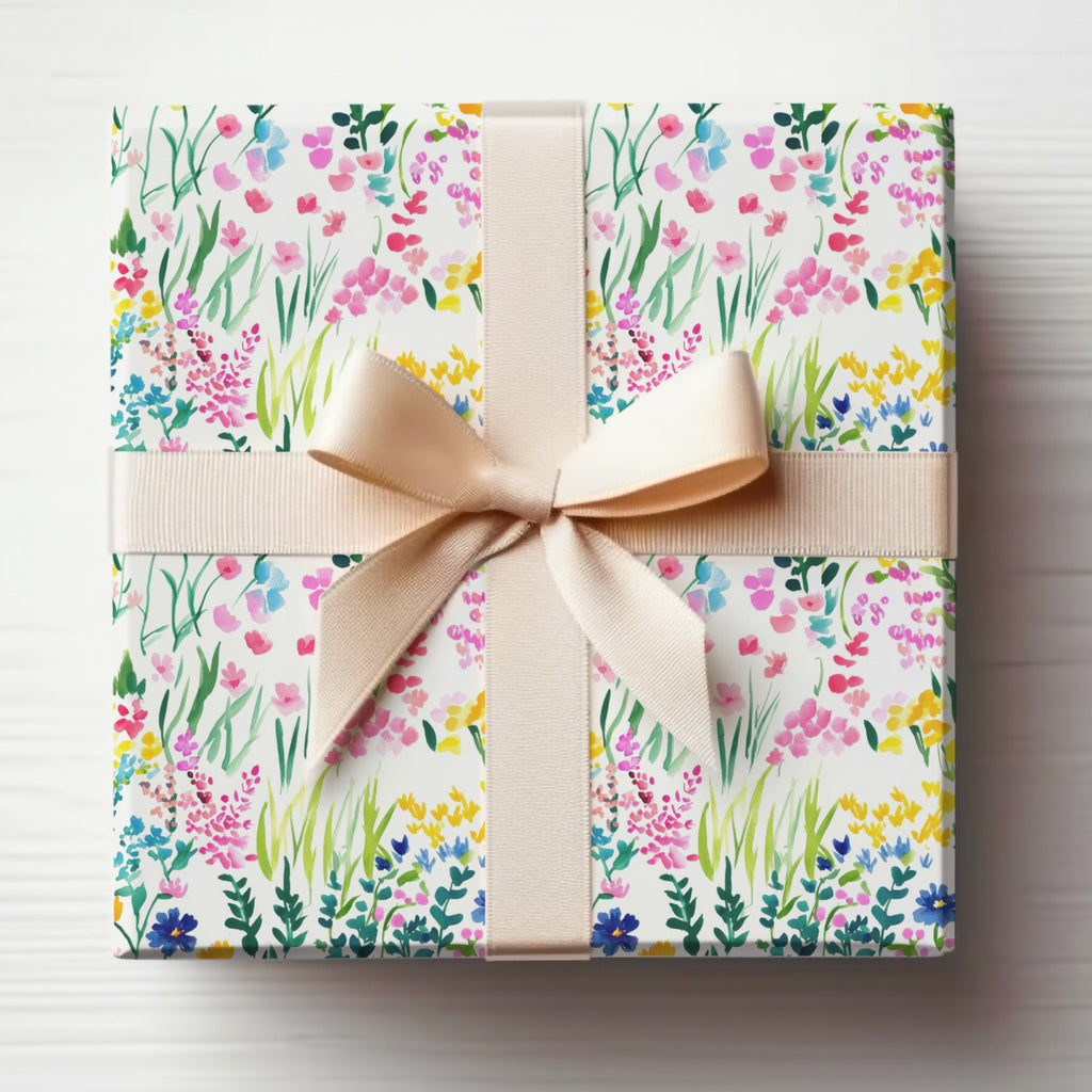 Gift-wrapped box with a watercolor floral pattern and a beige ribbon bow.
