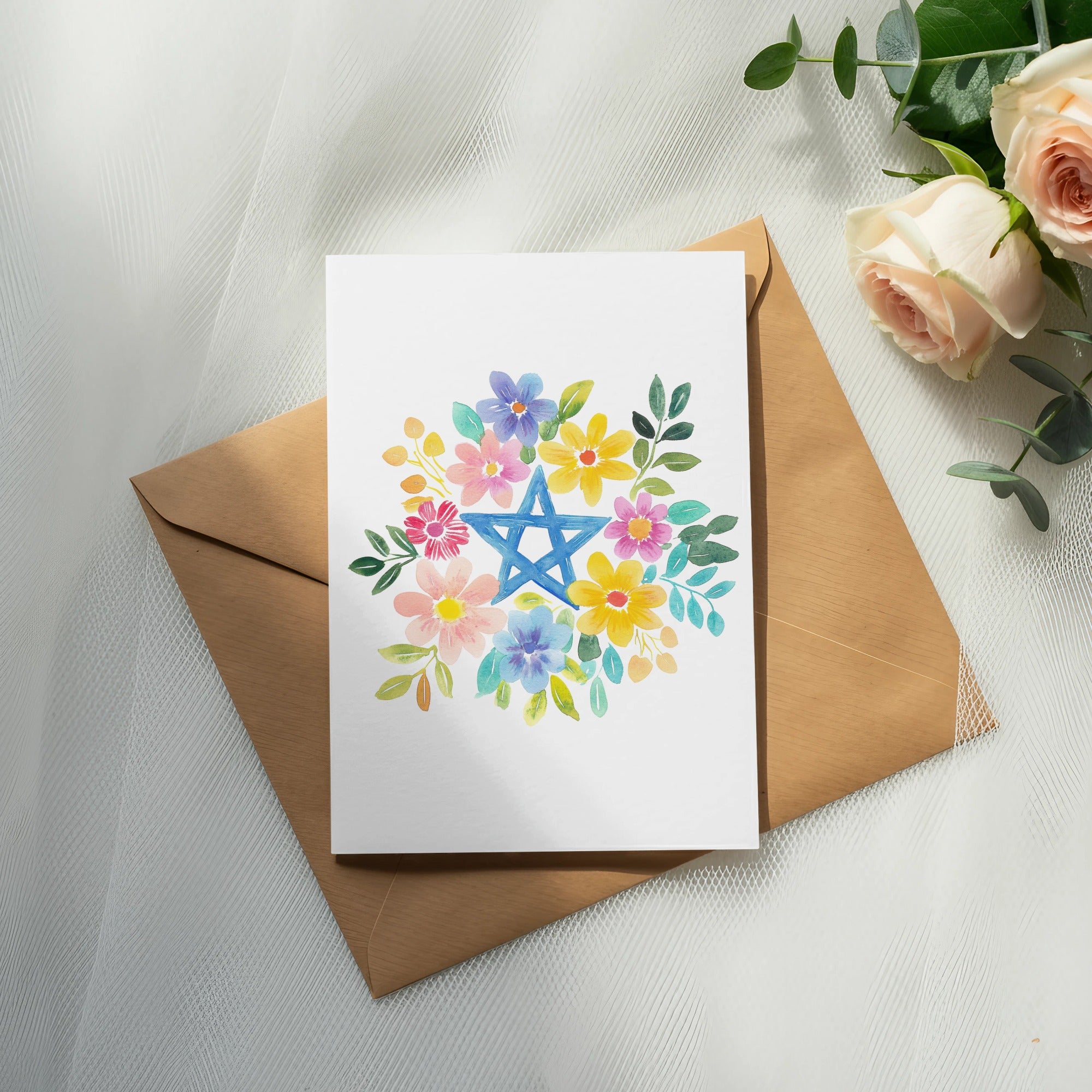 Floral arrangement with blue Star of David on a card and envelope.
