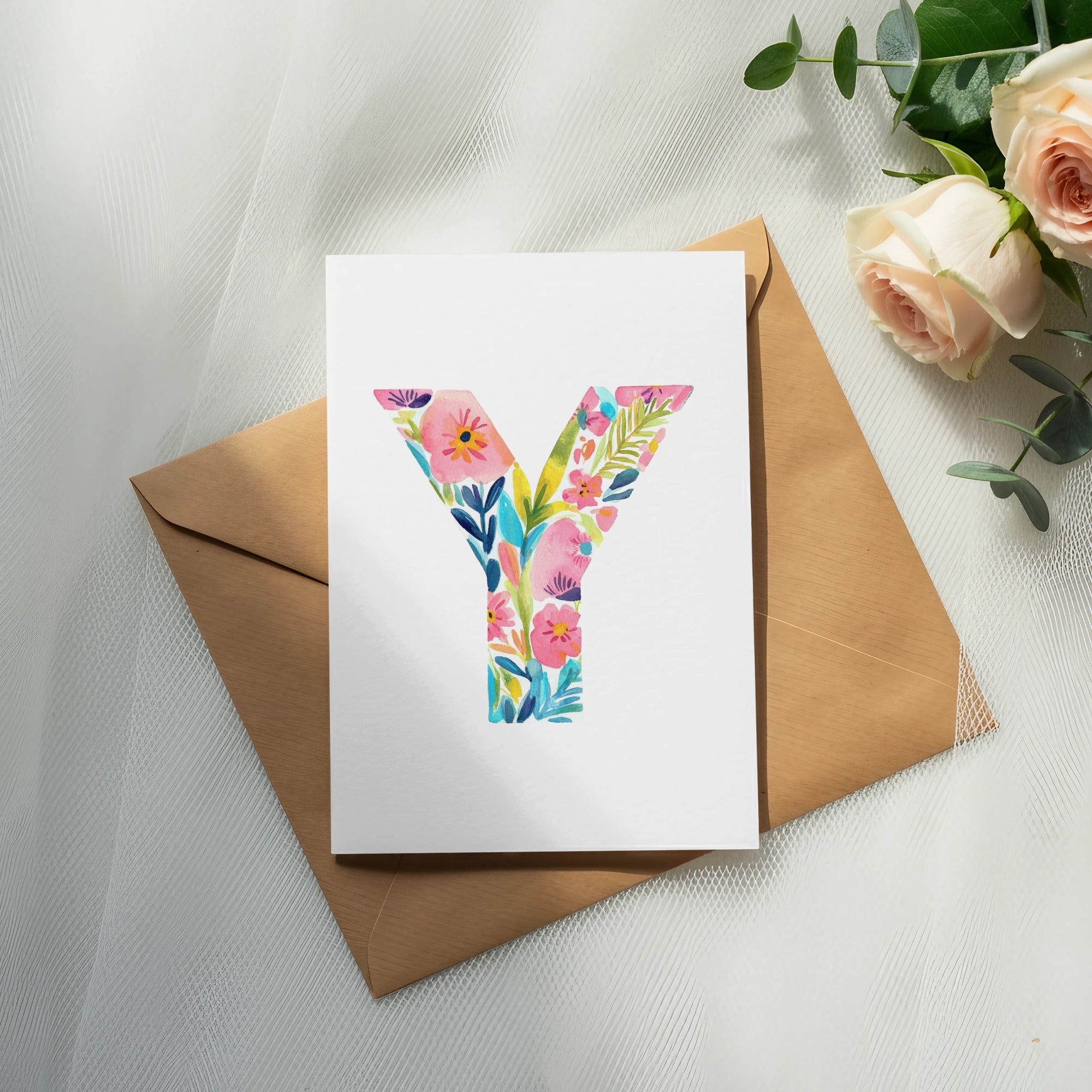Watercolor letter Y with floral design on a card with an envelope and roses.