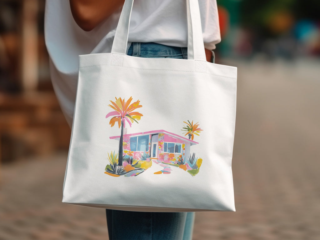 White tote bag with watercolor illustration of a pink mid-century modern house.