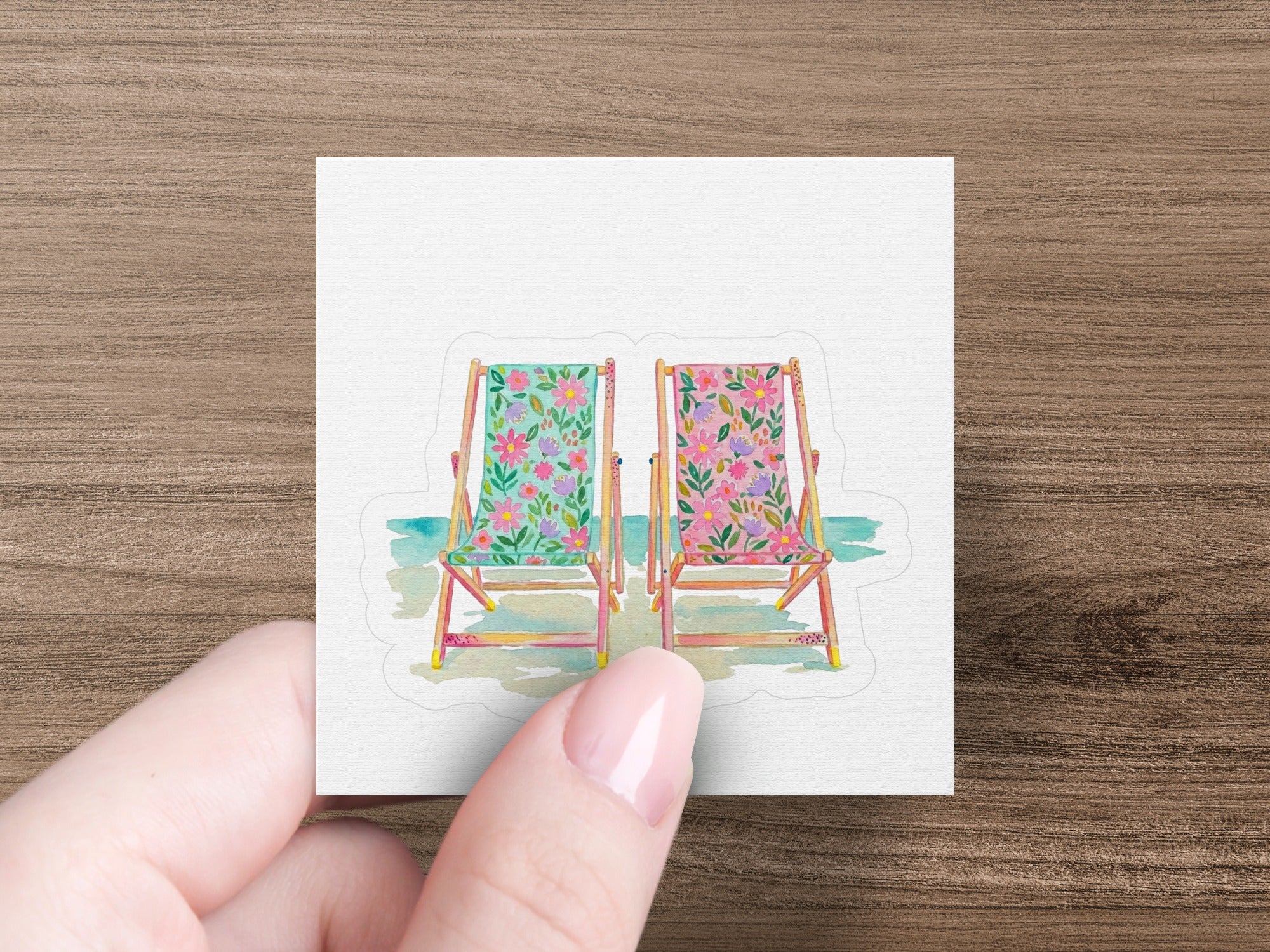 Two deck chairs with floral patterns and blue water.