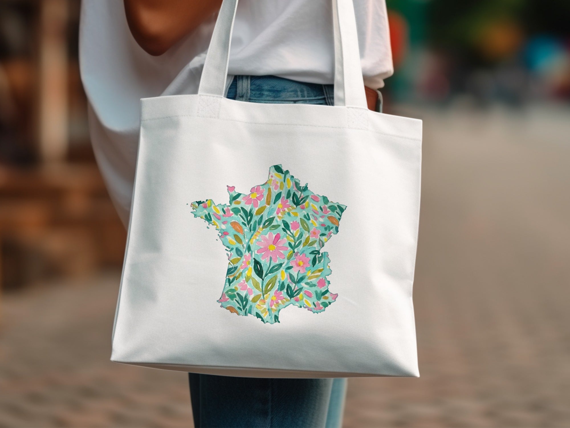 White tote bag with a watercolor floral map of France.