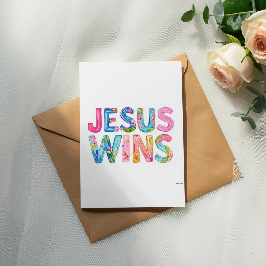 Card with "JESUS WINS" in colorful watercolor lettering on a brown envelope.