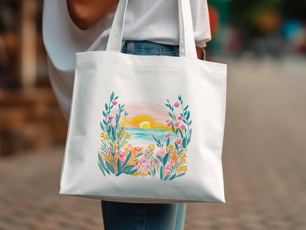 White canvas tote bag with a watercolor sunset and floral design.