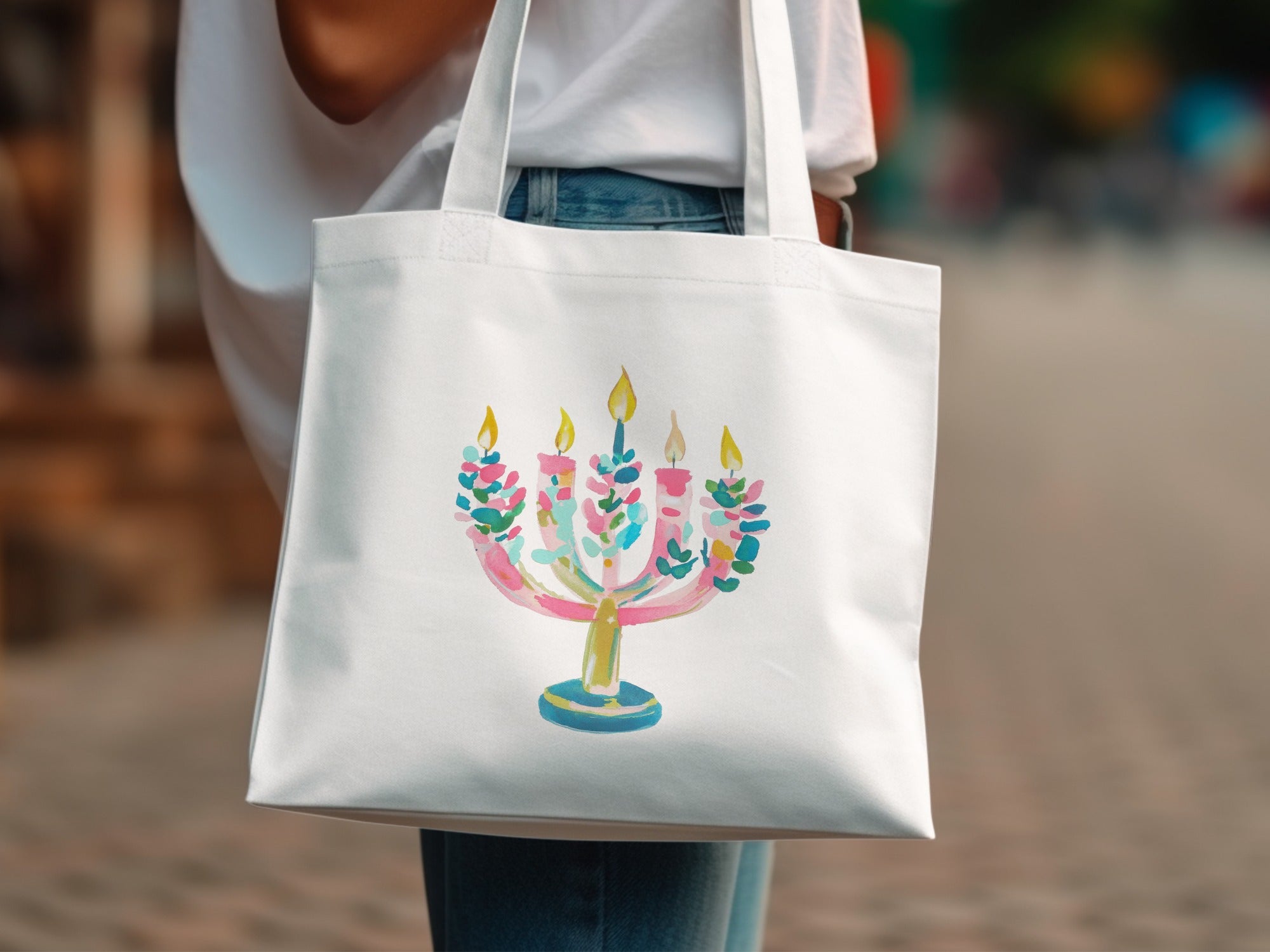 Watercolor menorah with colorful flames on a white tote bag.
