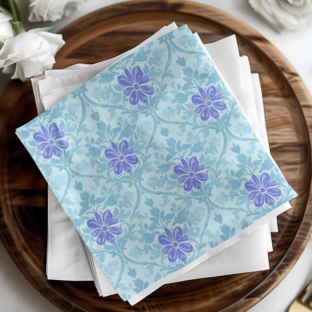 Blue fabric with purple floral pattern on white napkins, on wooden tray.
