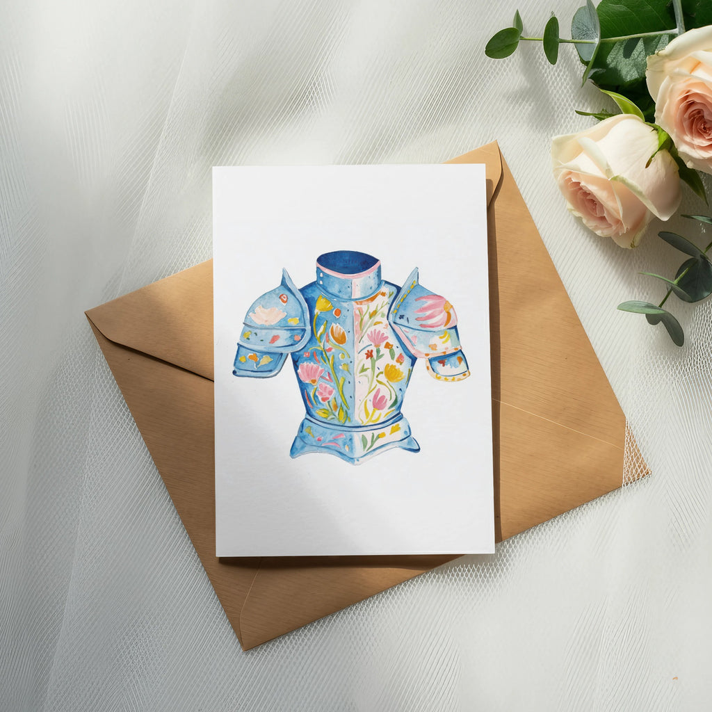 Watercolor illustration of a blue floral-decorated knight's breastplate on a card.