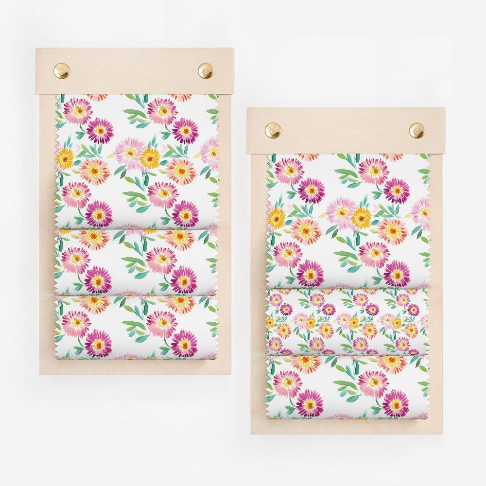 Fabric swatches with colorful floral pattern, displayed on wooden boards.