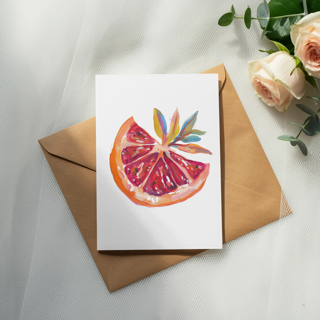 Watercolor painting of a grapefruit slice on a card, next to roses and eucalyptus.