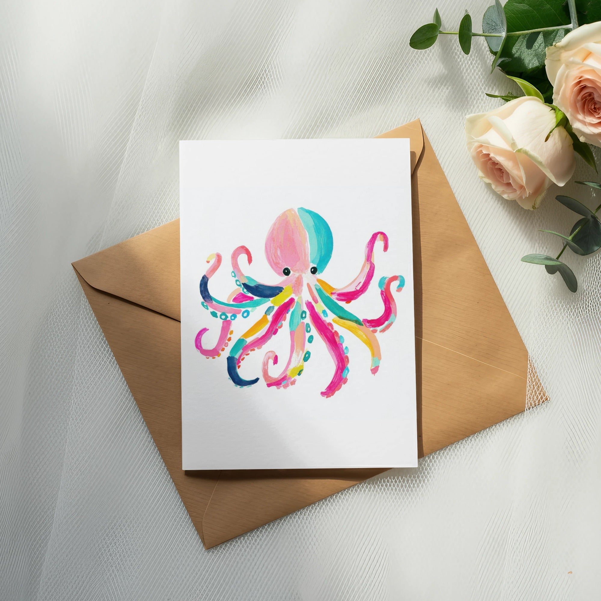 Colorful watercolor octopus illustration on a card, atop an envelope.