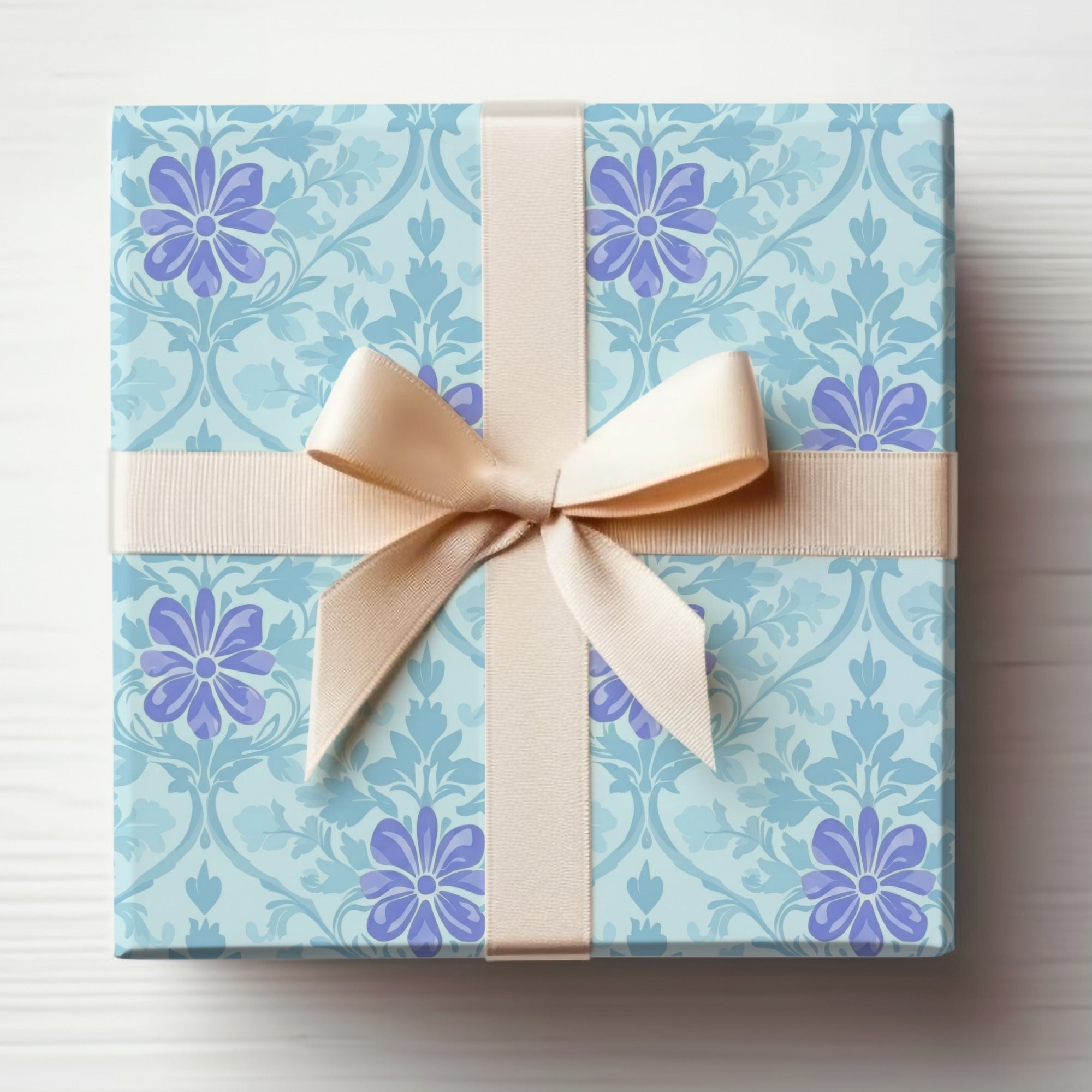 Light blue gift box with floral pattern and cream ribbon bow.