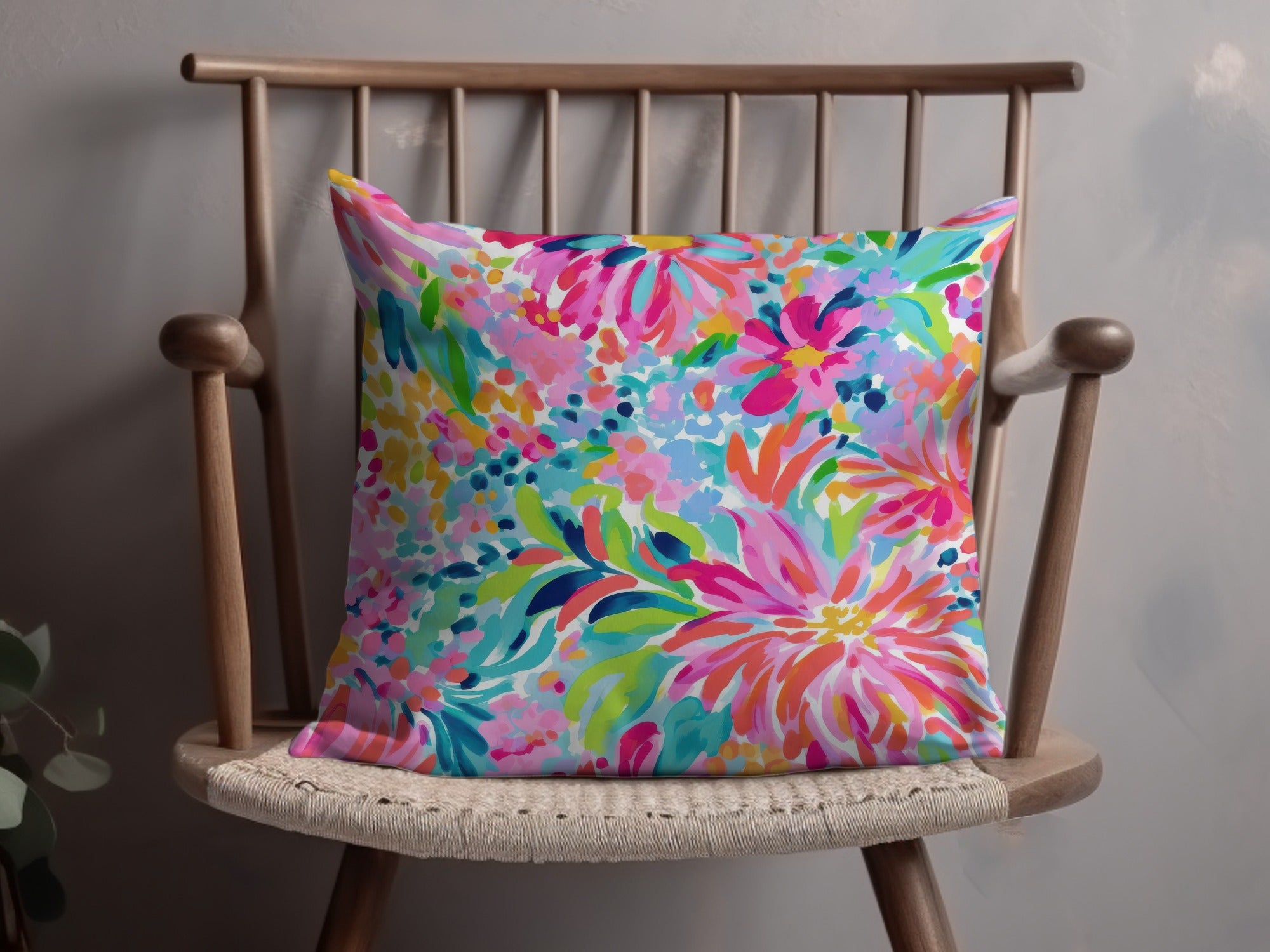 Throw pillow with a vibrant, colorful floral pattern on a wooden chair.