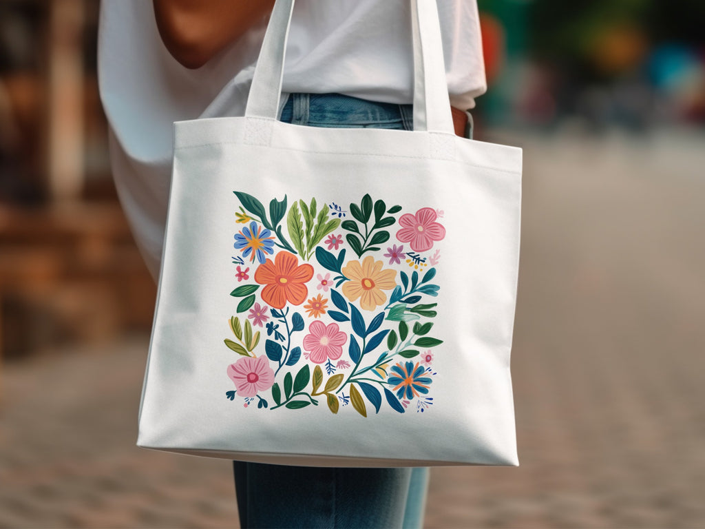 White tote bag with colorful floral and leaf illustration.