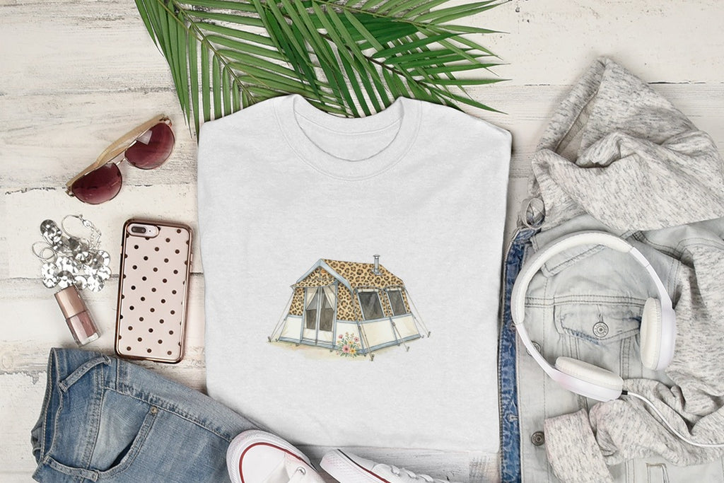 White t-shirt with leopard print tent graphic, surrounded by jeans, sunglasses, and headphones.