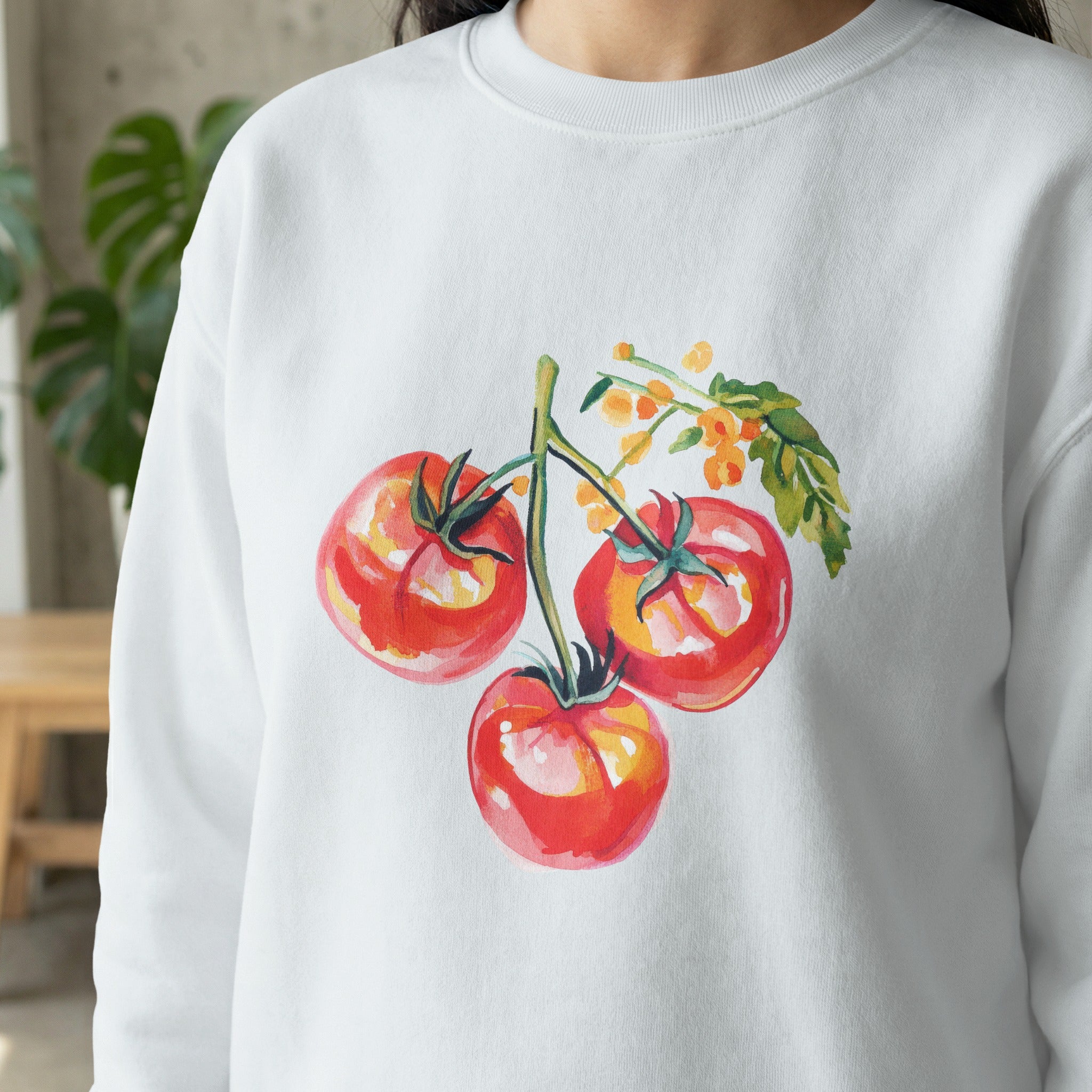 White sweatshirt with watercolor illustration of three ripe red tomatoes on a vine.