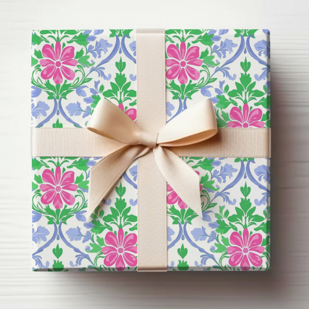 Gift-wrapped box with pink flowers and blue vines, tied with a beige ribbon.
