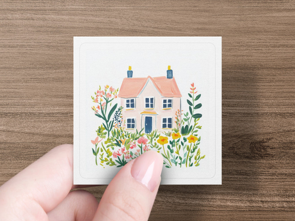 Pink cottage with blue doors surrounded by colorful flowers and greenery.