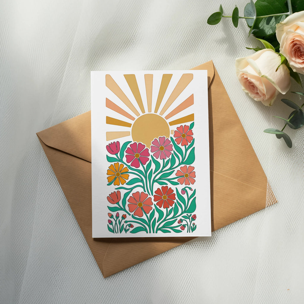 Card with colorful floral design and sunburst on a brown envelope.