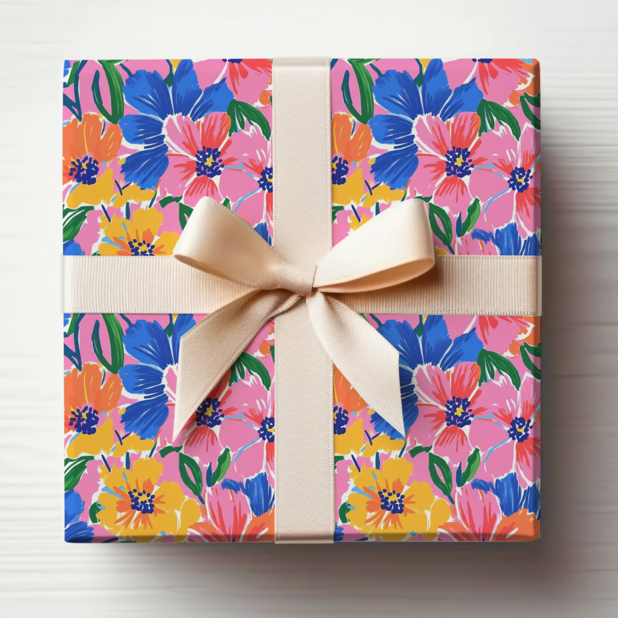 Gift-wrapped box with bold floral pattern and cream ribbon bow.