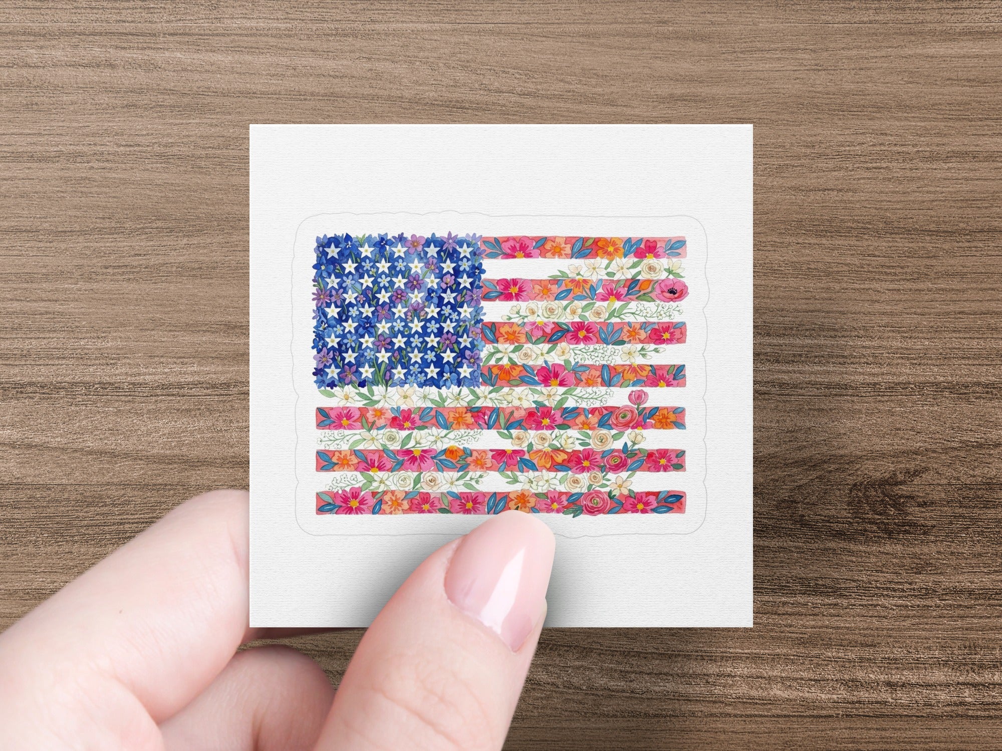 American flag with floral stripes held by a hand.
