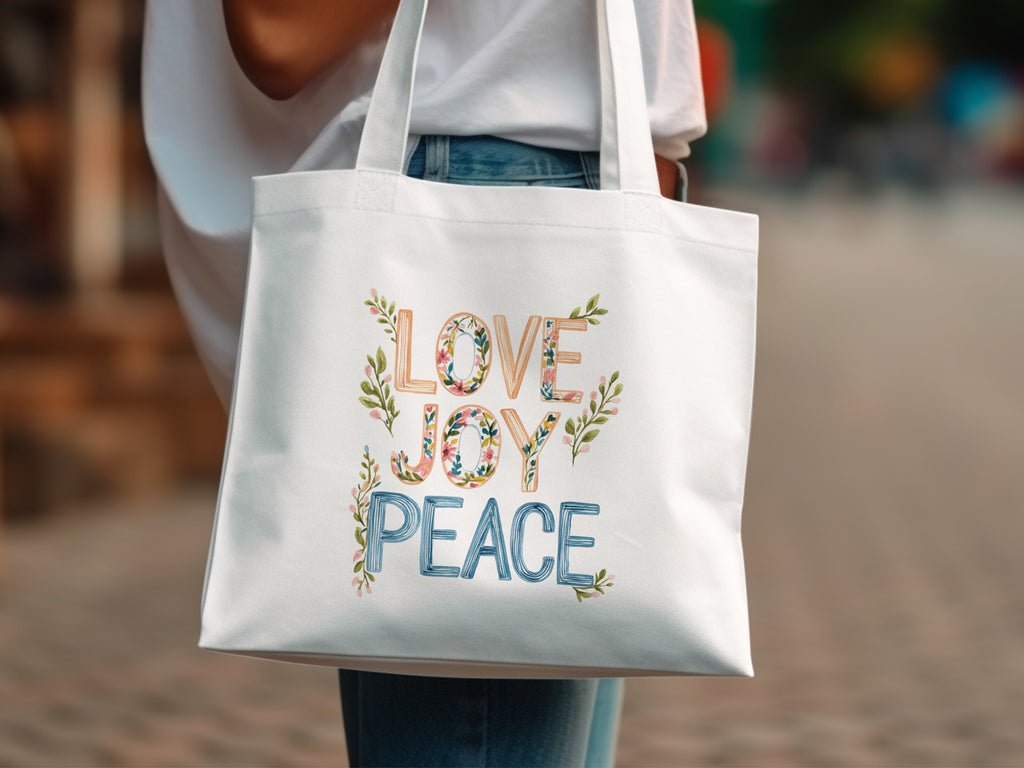 White tote bag with "LOVE JOY PEACE" text and floral accents.