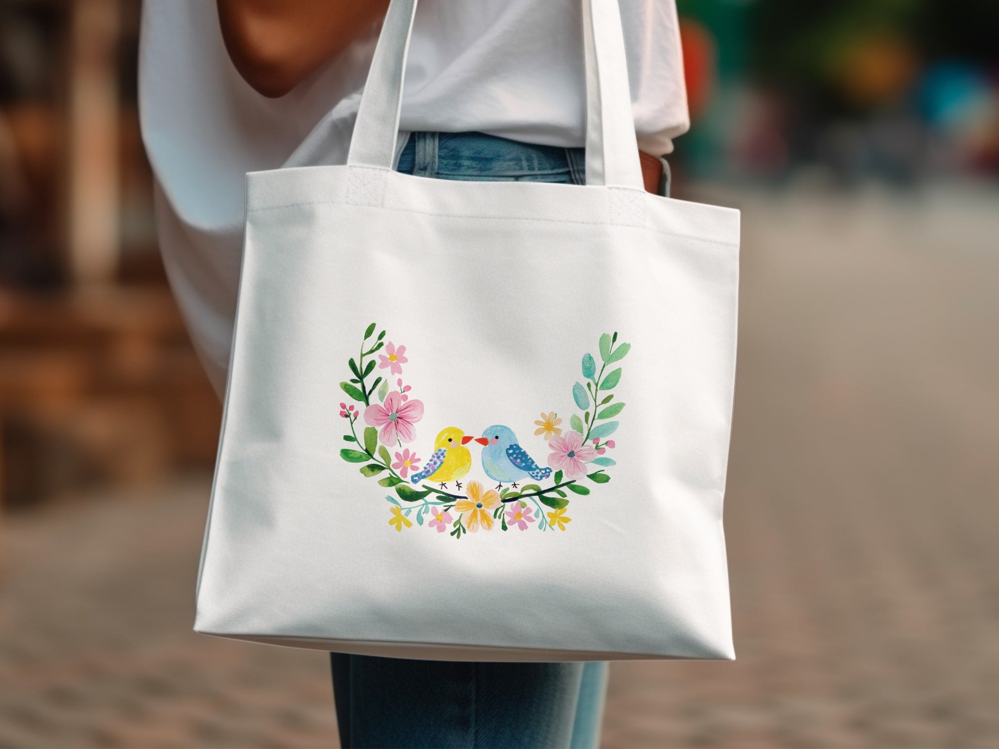 White tote bag with a floral wreath and two small birds.