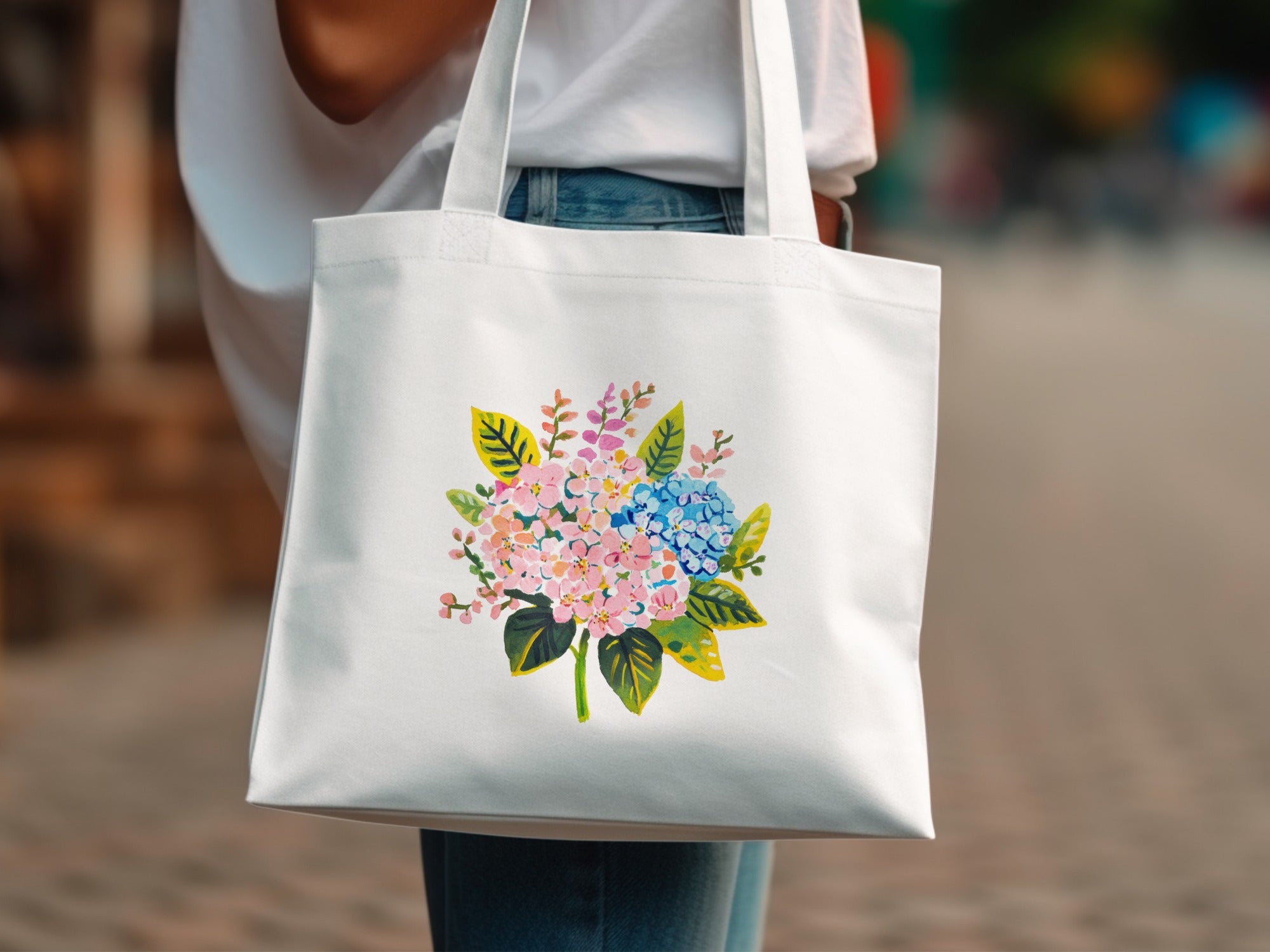 White tote bag featuring a colorful floral bouquet illustration.