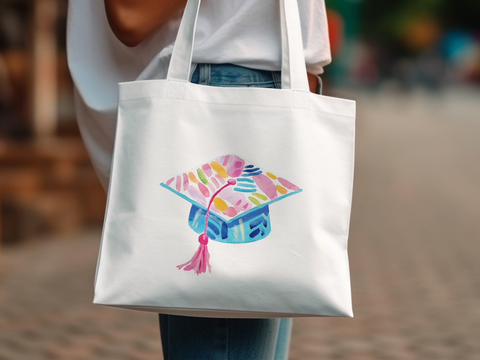 White canvas tote bag with watercolor graduation cap design.