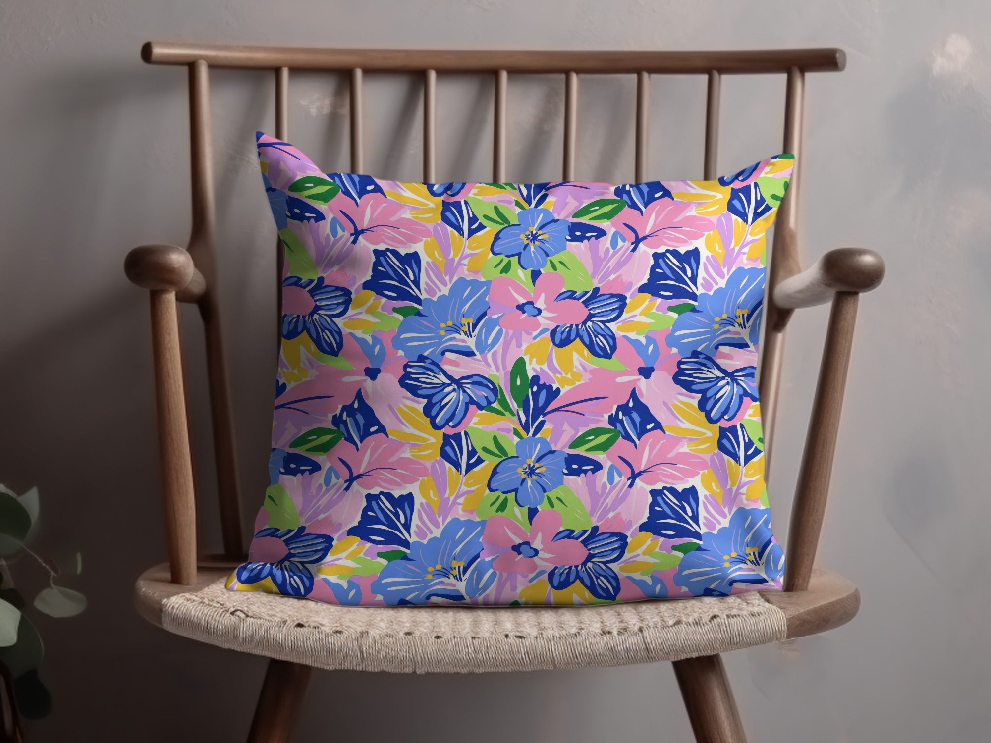 Colorful floral pattern throw pillow on a wooden chair.