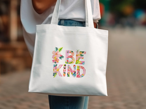 White tote bag with "BE KIND" text in floral watercolor letters.