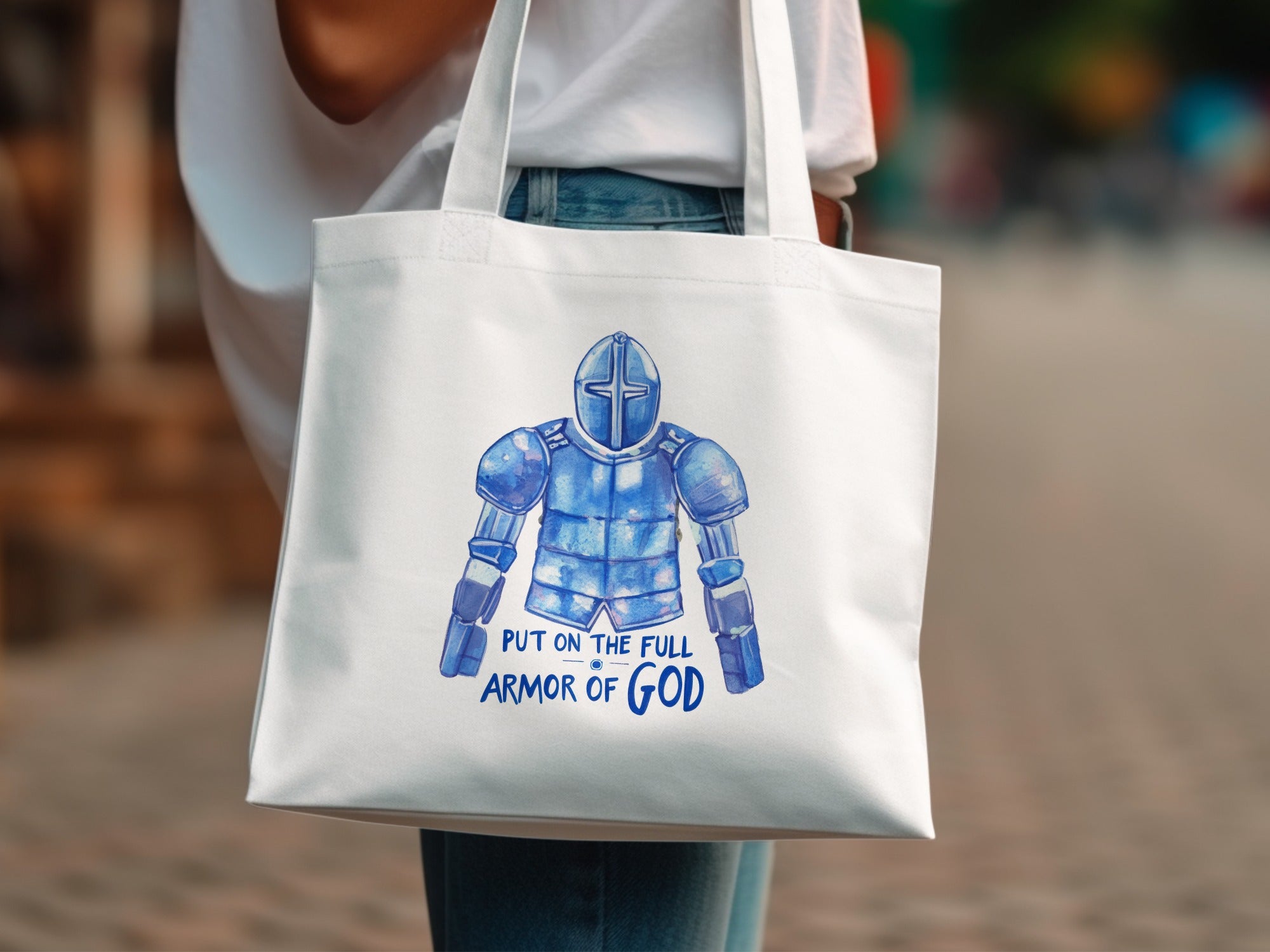 White tote bag with watercolor illustration of full armor and text "Put on the Full Armor of God".