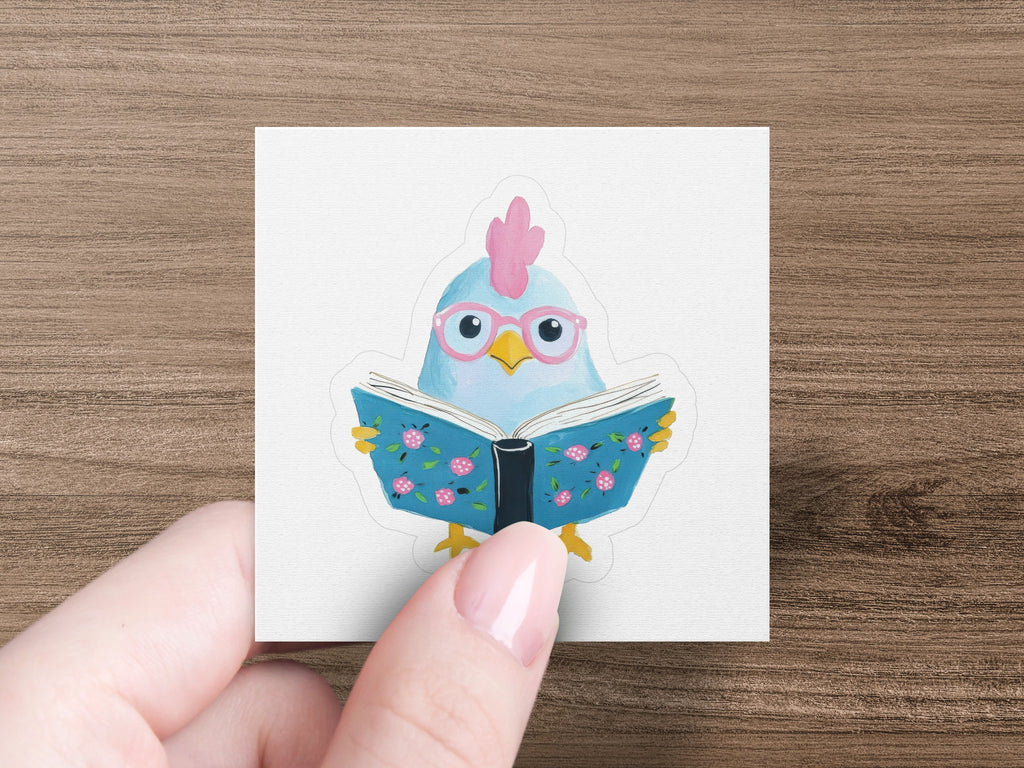 Cartoon chicken with pink glasses reading a book with blue floral pages.