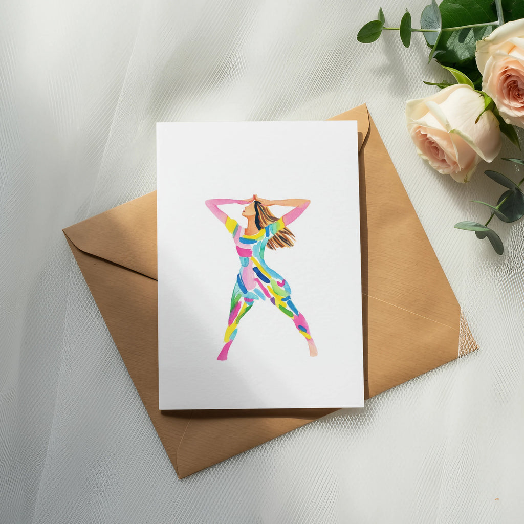 Card with colorful abstract figure on brown envelope with roses and eucalyptus.