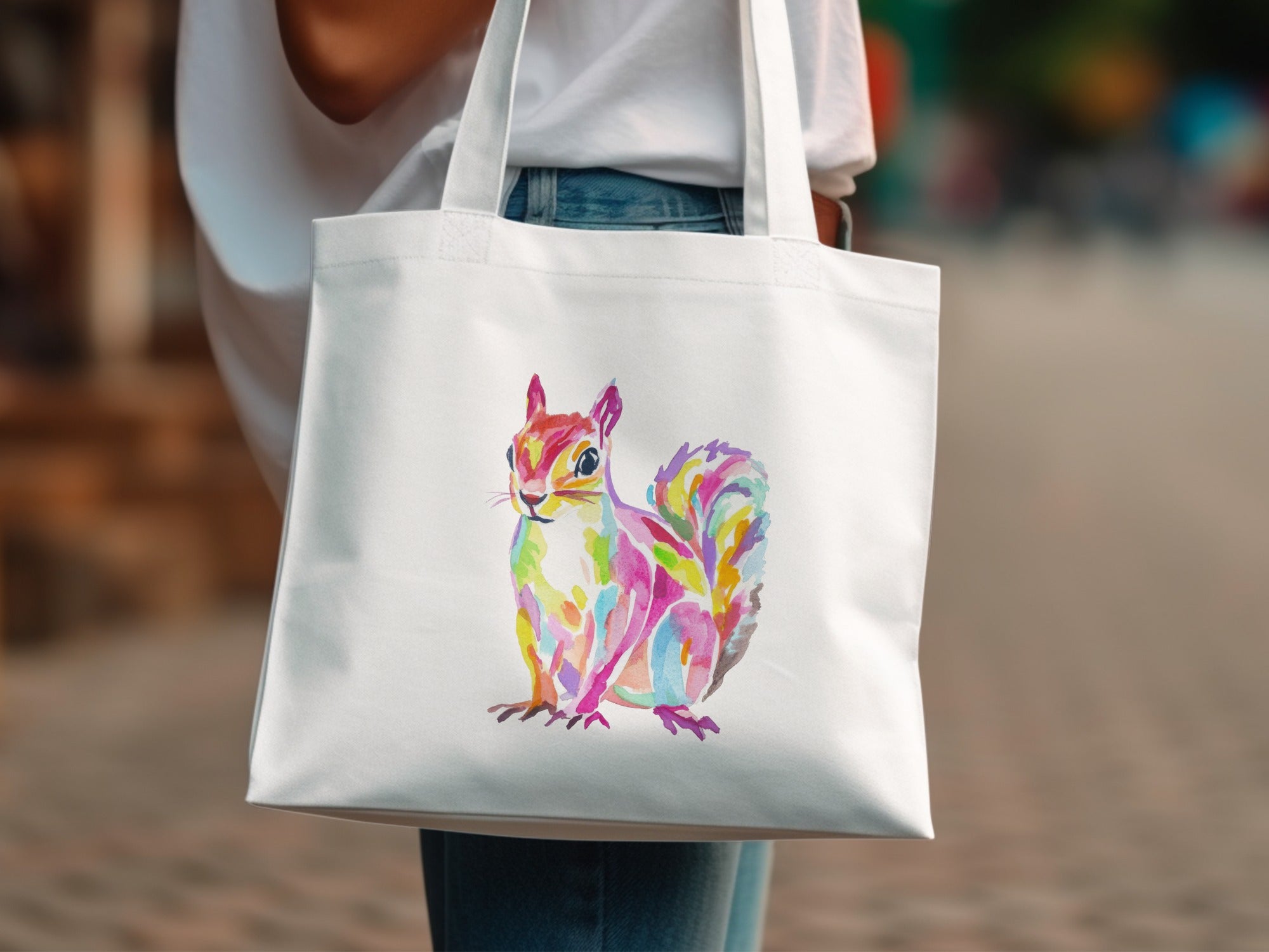 White tote bag with a colorful watercolor squirrel illustration.